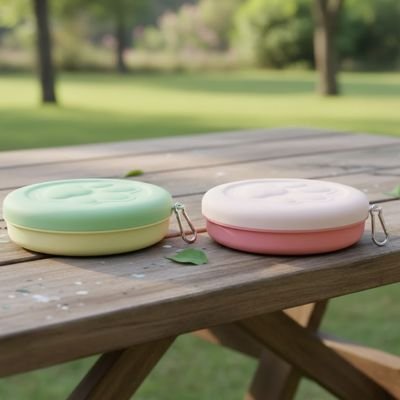 gamelle pour chat voyage couleur vert pastel et rose en exterieur sur table